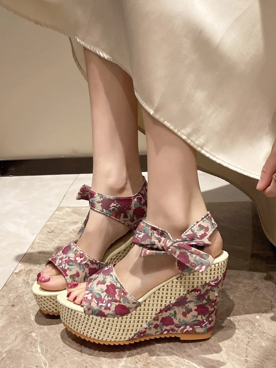 Floral bow wedge sandals with a woven wedge and ankle strap detail.