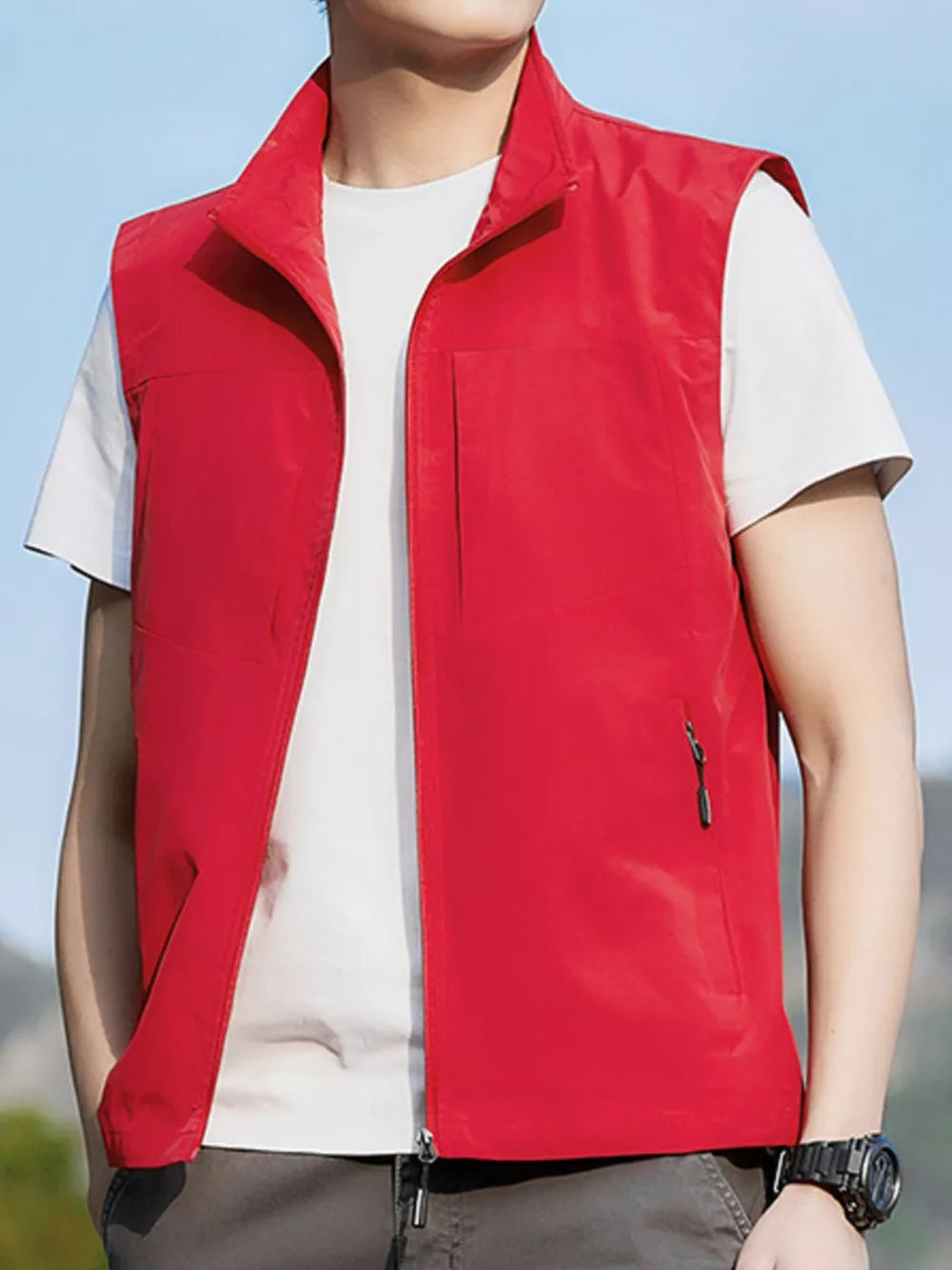 Red zip up vest with stand collar and zippered pockets, worn over a white t-shirt.
