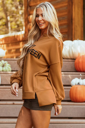 Caramel graphic sweatshirt with slit hem and v-neck, styled with shorts.