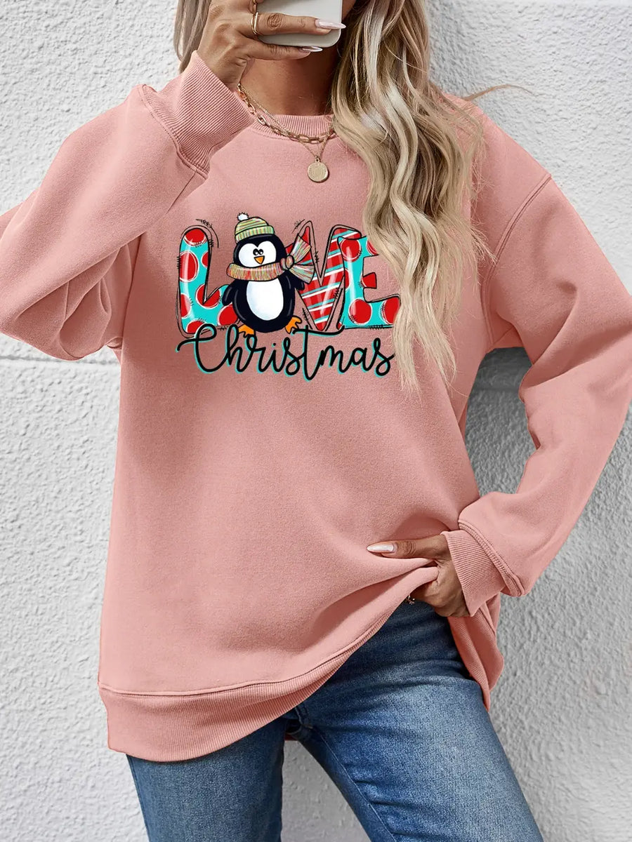 Blush pink crewneck sweatshirt with festive penguin and "LOVE Christmas" graphic.
