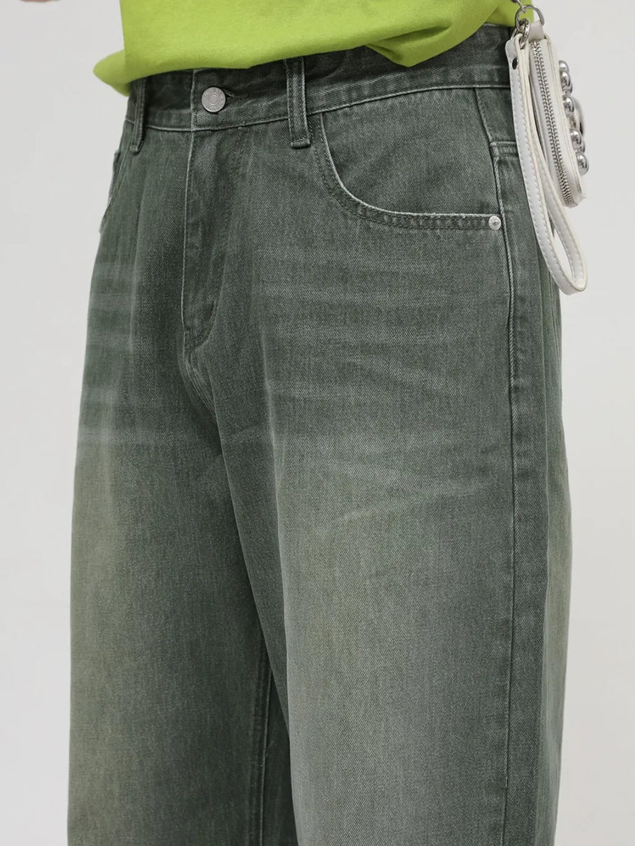 Faded olive wide leg denim jeans with a relaxed fit and visible pocket details.