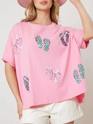 Pink polyester t-shirt with allover flip-flop print and short sleeves.
