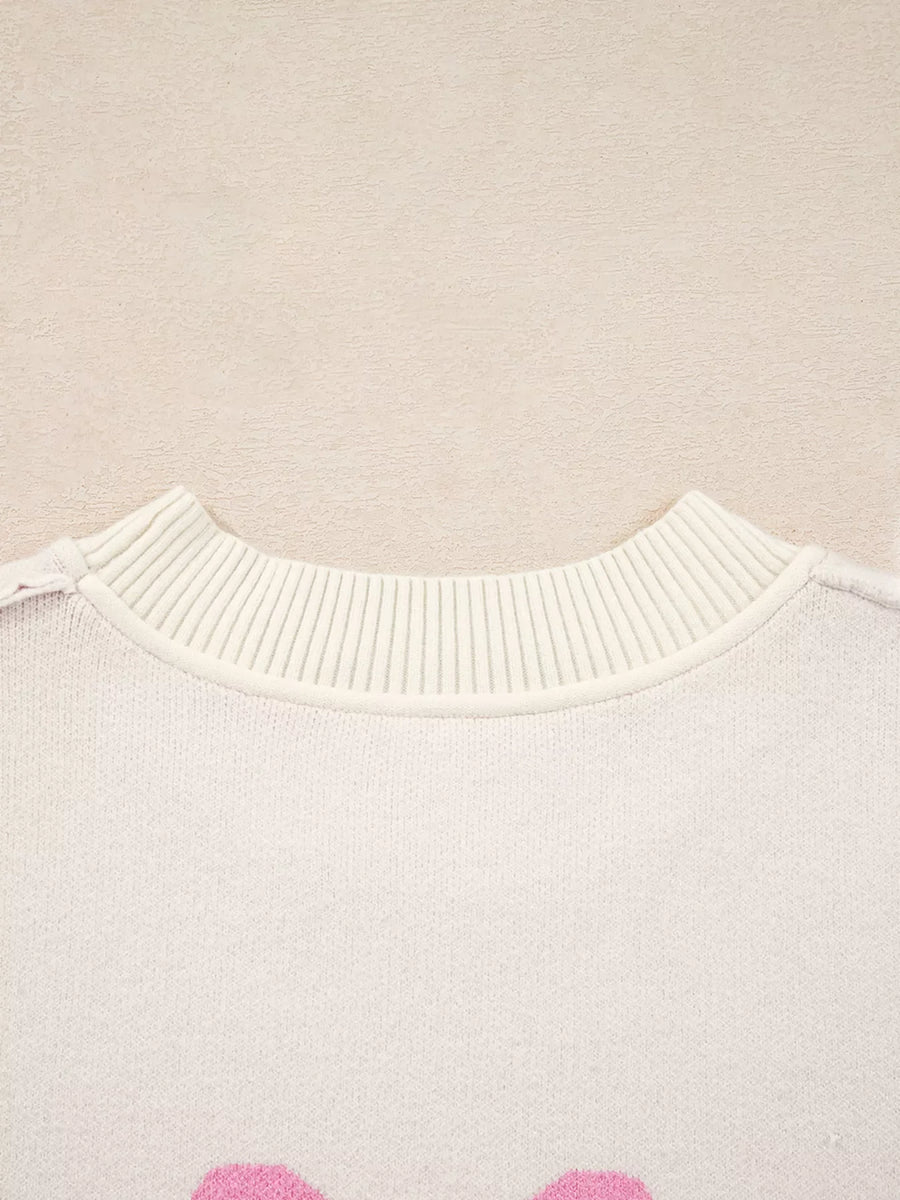Beige acrylic blend sweater with pink bow print and ribbed crew neck.