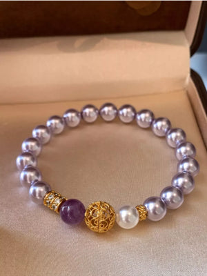 Pearl beaded bracelet with gold accents, amethyst and crystal details