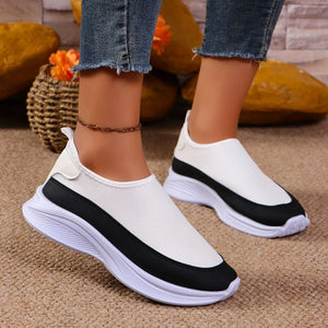 White mesh slip-on sneakers with black stripe detail and white soles