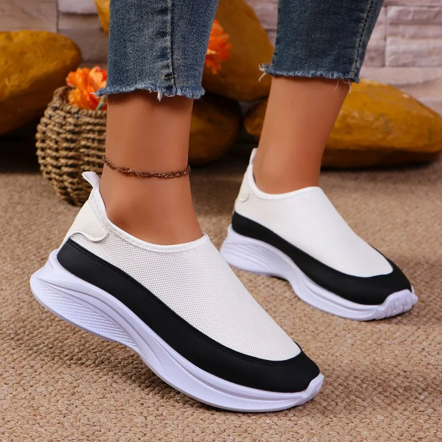 White mesh slip-on sneakers with black stripe detail and white soles