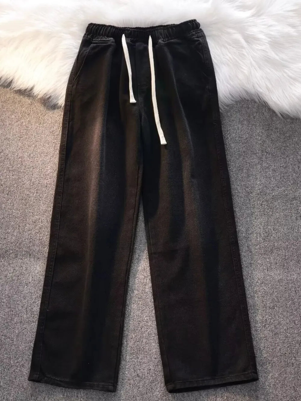 Black vintage wash wide-leg jeans with drawstring and elastic waist.