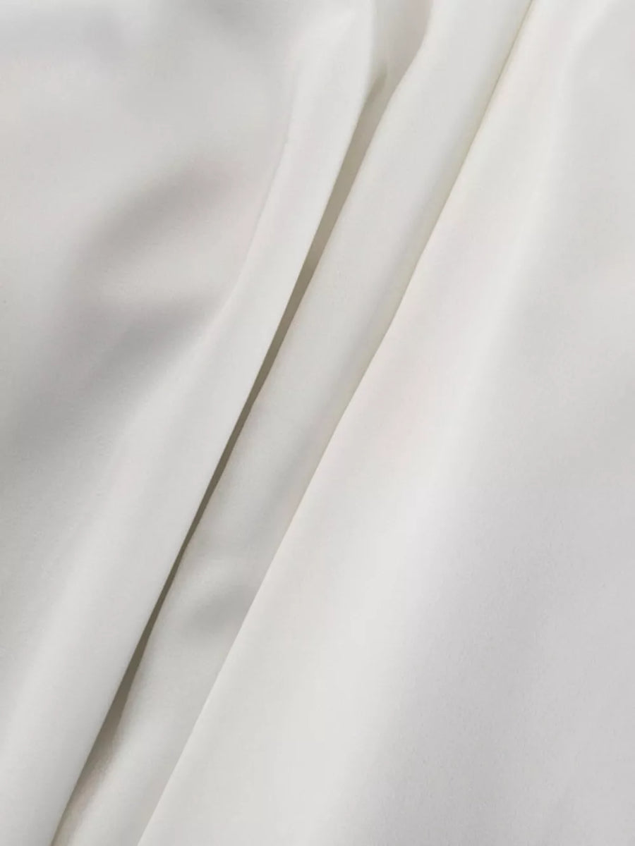 White satin fabric with soft folds and a subtle sheen