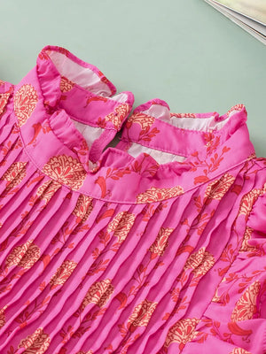 Pink floral print pleated blouse with ruffled mock neck and flutter sleeves.
