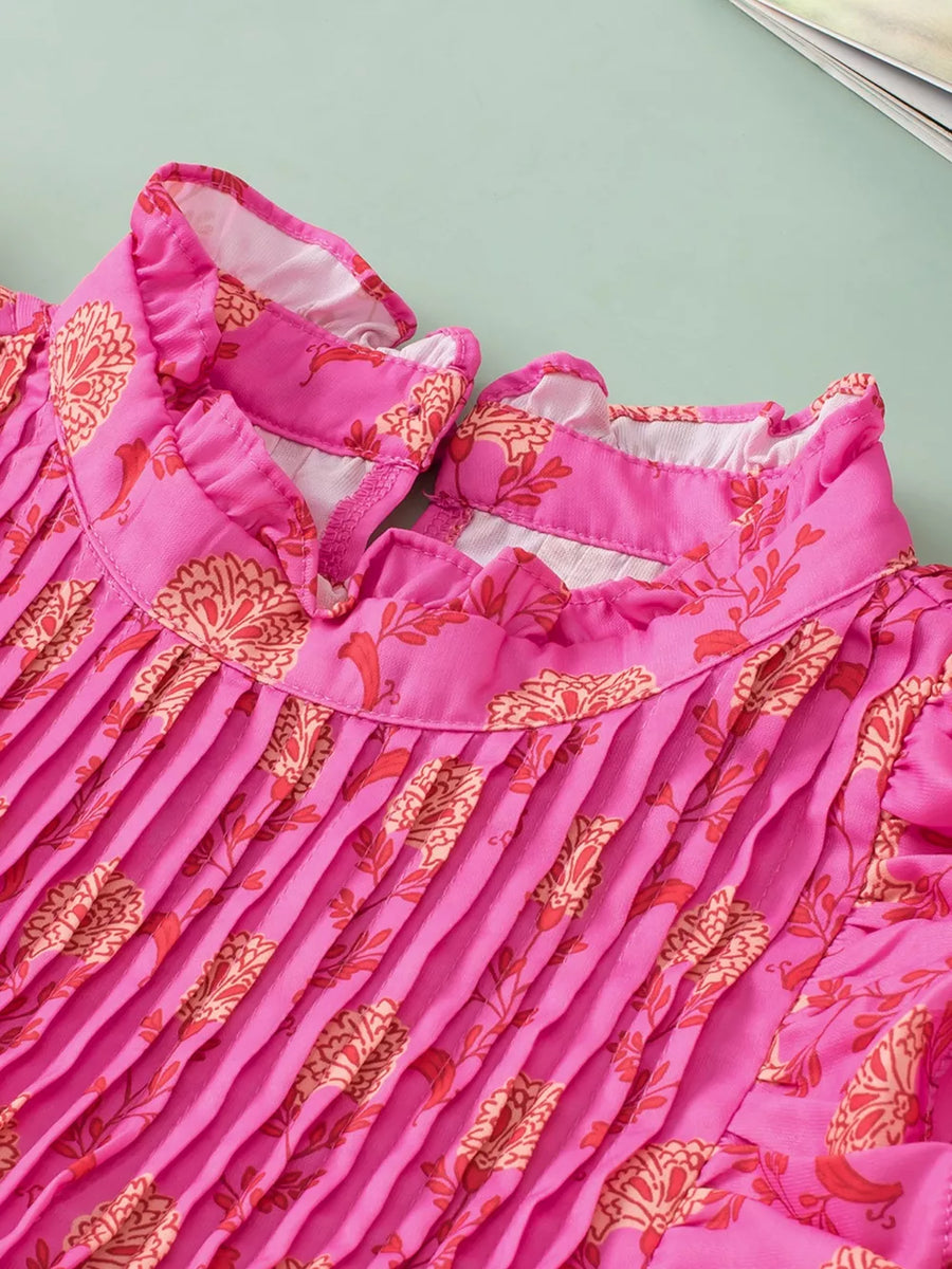 Pink floral print pleated blouse with ruffled mock neck and flutter sleeves.