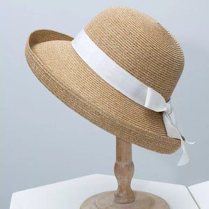 Elegant straw sun hat with white ribbon detail and bow