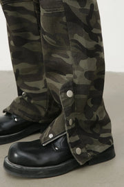 Camouflage utility flare trousers with snap-button leg details and zippers, styled with black boots.