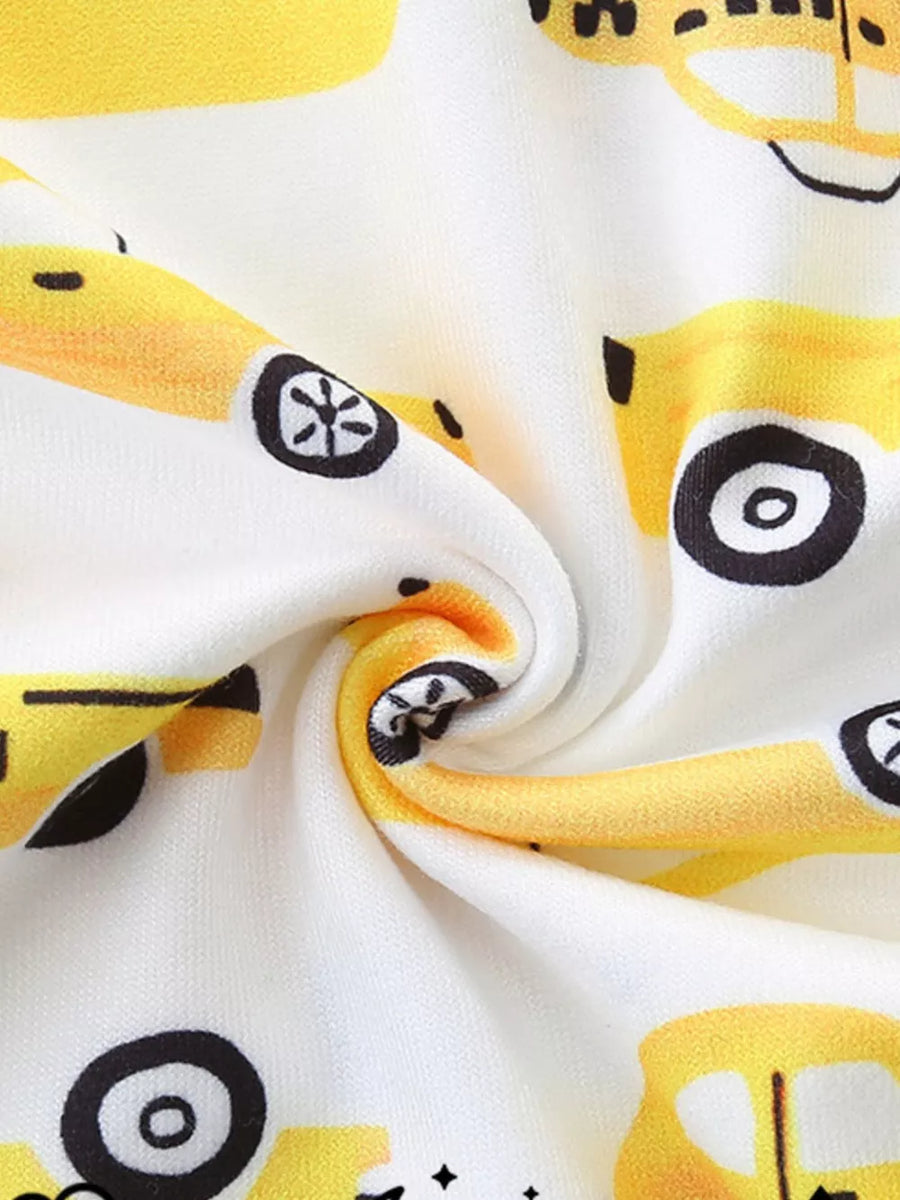 Toddler pajama set with yellow cartoon car print on white fabric.