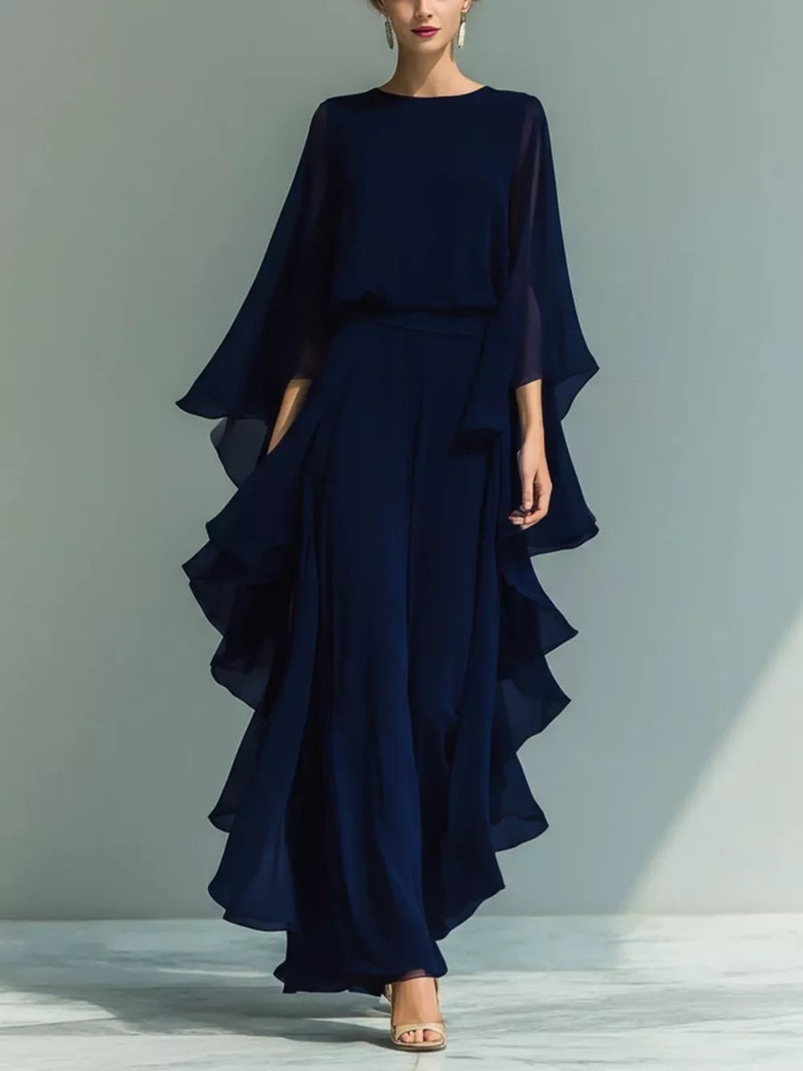 Navy chiffon cape dress with ruffled tiered skirt and round neckline.