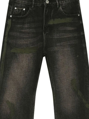 Faded wash bootcut jeans in dark denim with green paint-splatter details.