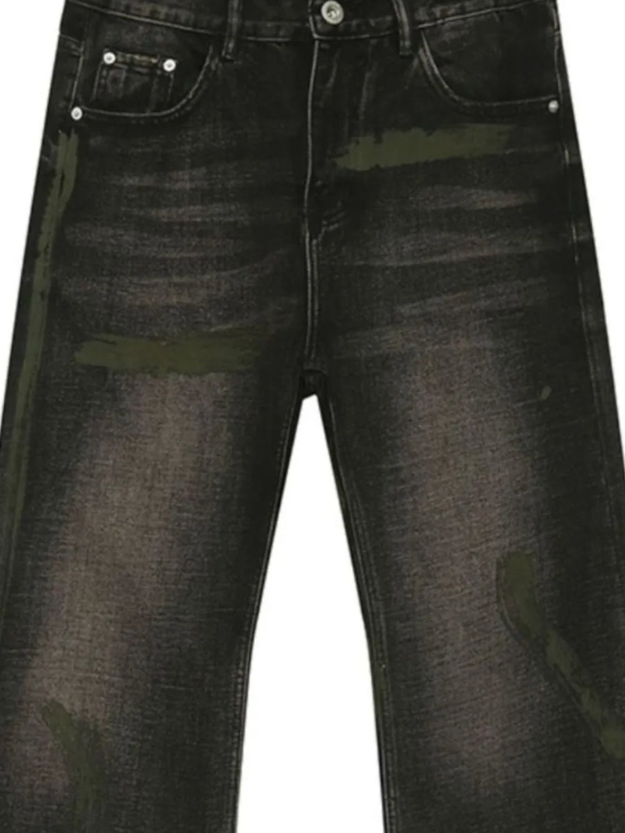 Faded wash bootcut jeans in dark denim with green paint-splatter details.