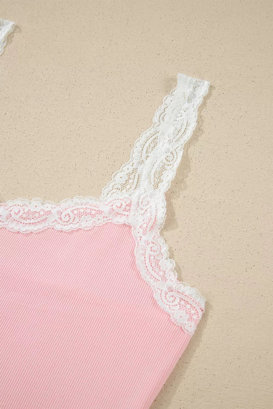 Pink ribbed cami pajama top with white lace trim and straps.