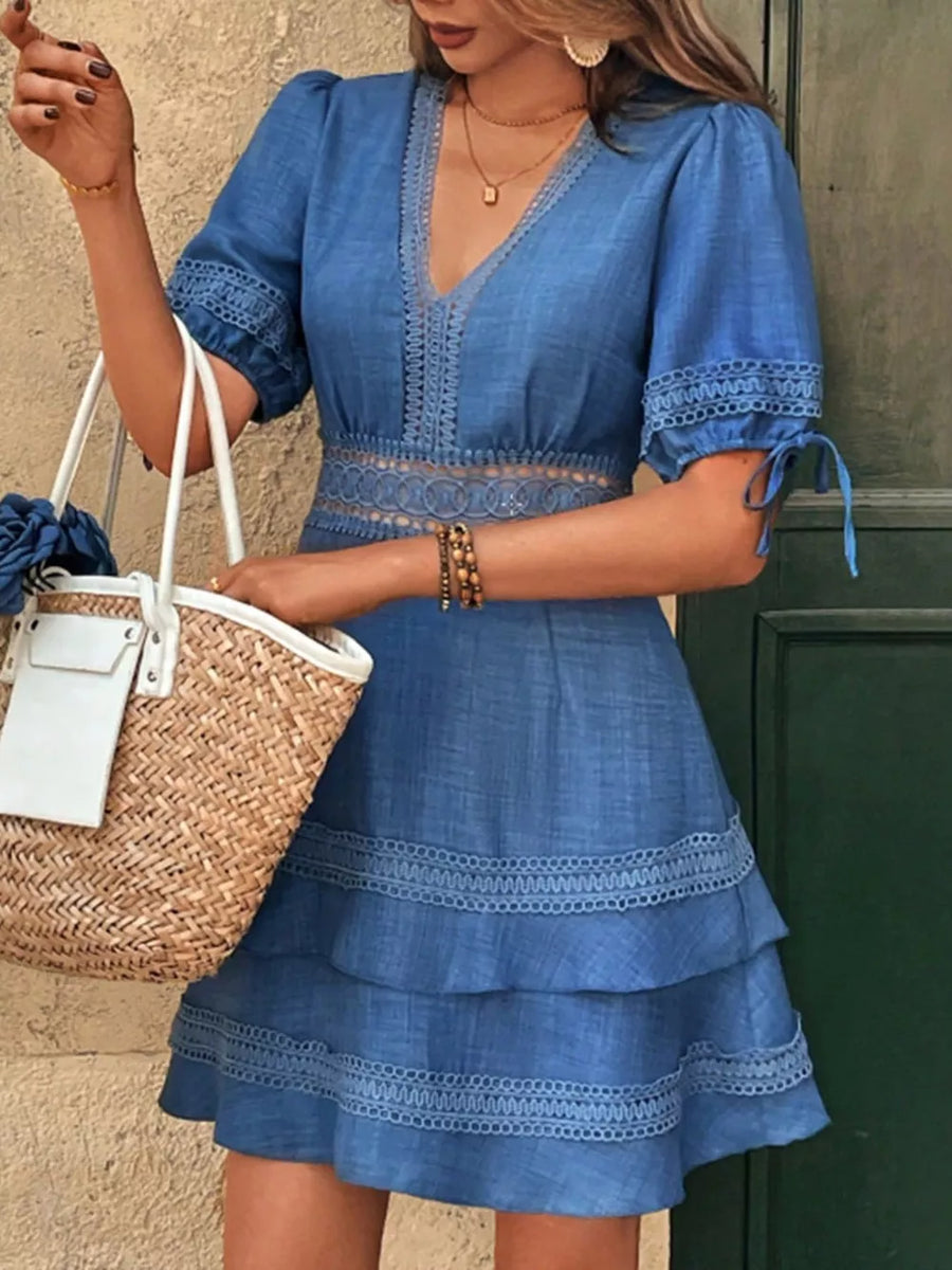 Blue lace-embellished V-neck mini dress with tiered skirt and tie sleeves.