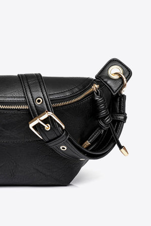 Black leather crescent crossbody bag with gold buckle and chain detail.