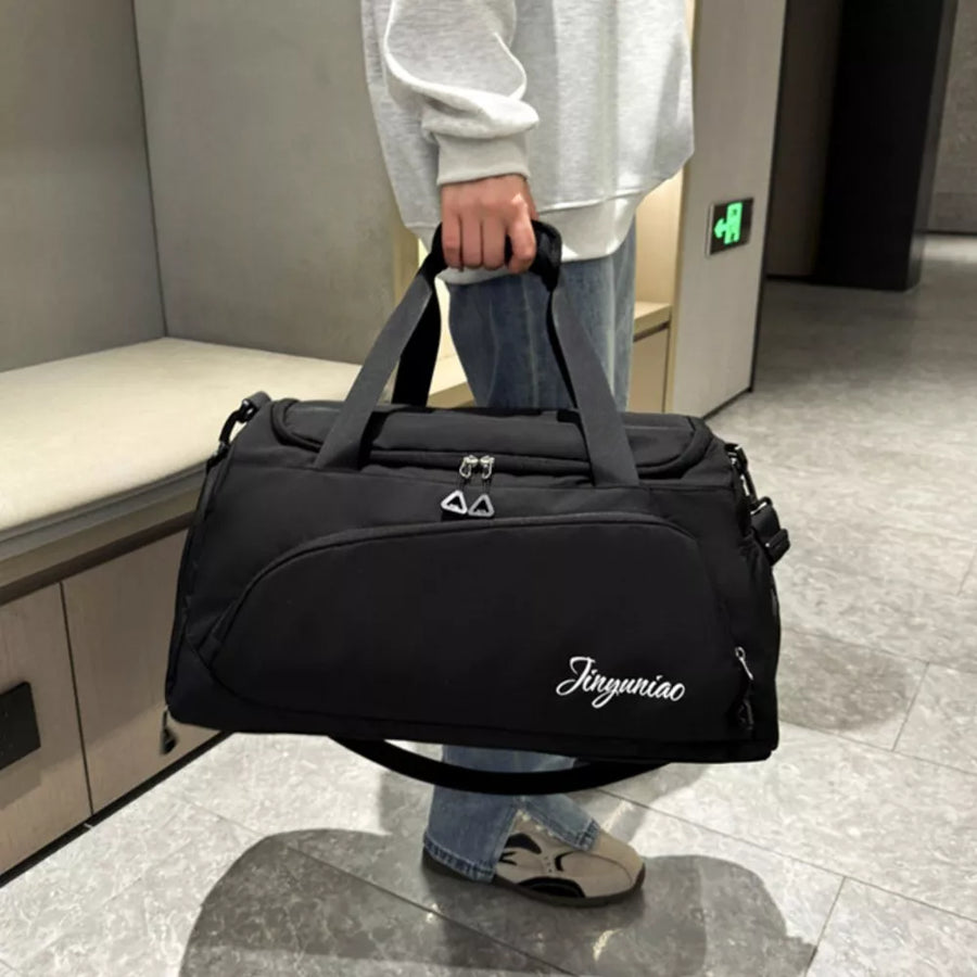 Black waterproof duffel bag with multiple pockets and white script logo detail.