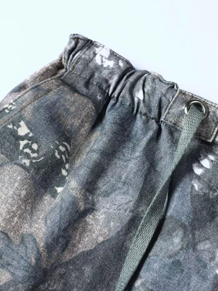 Men's camouflage cargo sweatpants with drawstring waist and metal eyelet detail.
