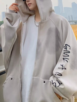 Oversized zip-up hoodie in apricot with graphic print on sleeve and front pockets.