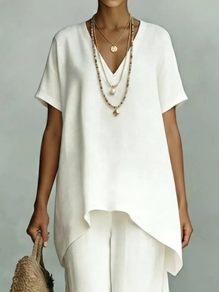 White linen blend v-neck short sleeve asymmetrical tunic top with layered necklaces.