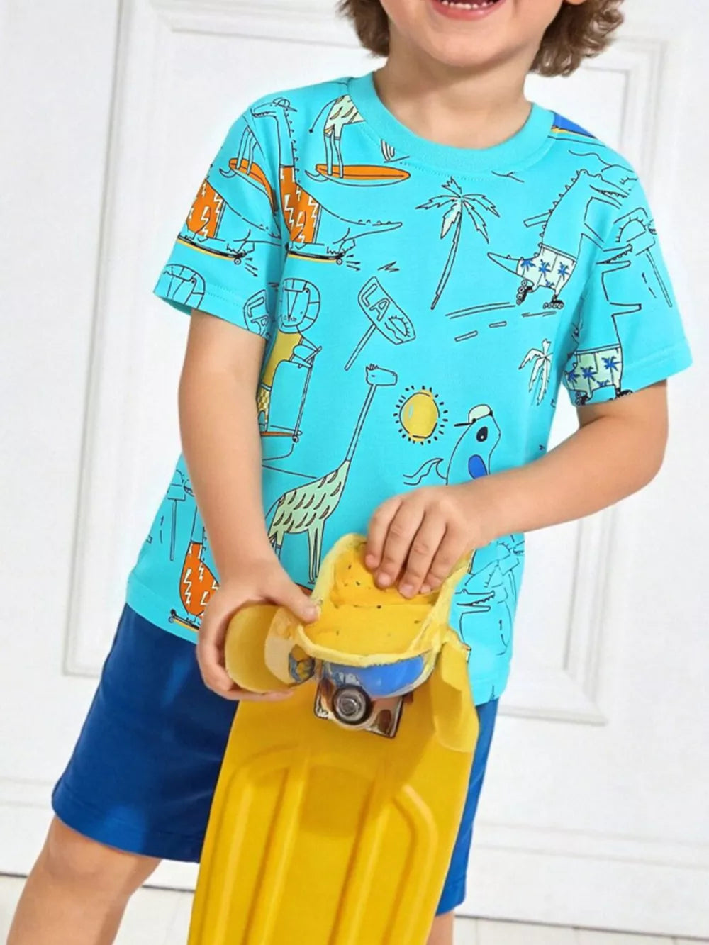 Aqua cotton t-shirt with playful cartoon print of dinosaurs and giraffes on skateboards.