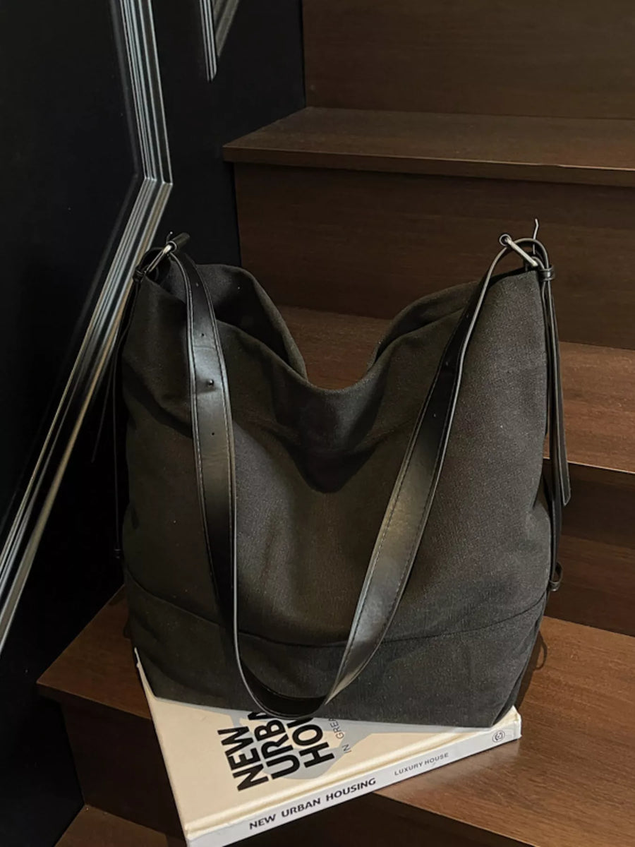 Black hobo bag with adjustable leather strap and canvas body.