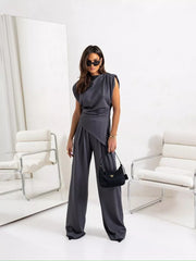 Gray satin cowl neck two-piece set with wide-leg pants and padded shoulders.