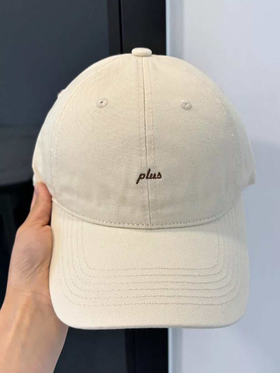 Cream white baseball cap with embroidered "plus" detail