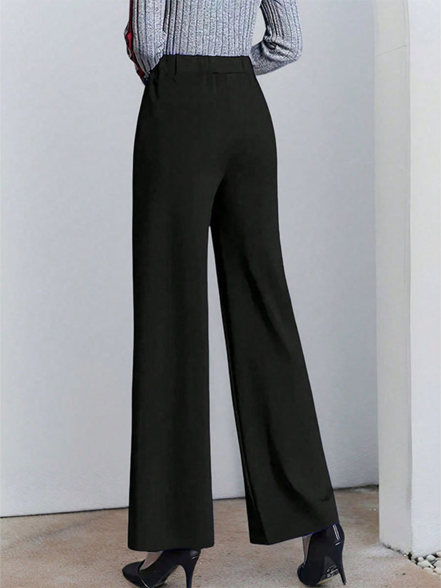 Black high-waisted wide leg cotton trousers with pockets, shown from the back.