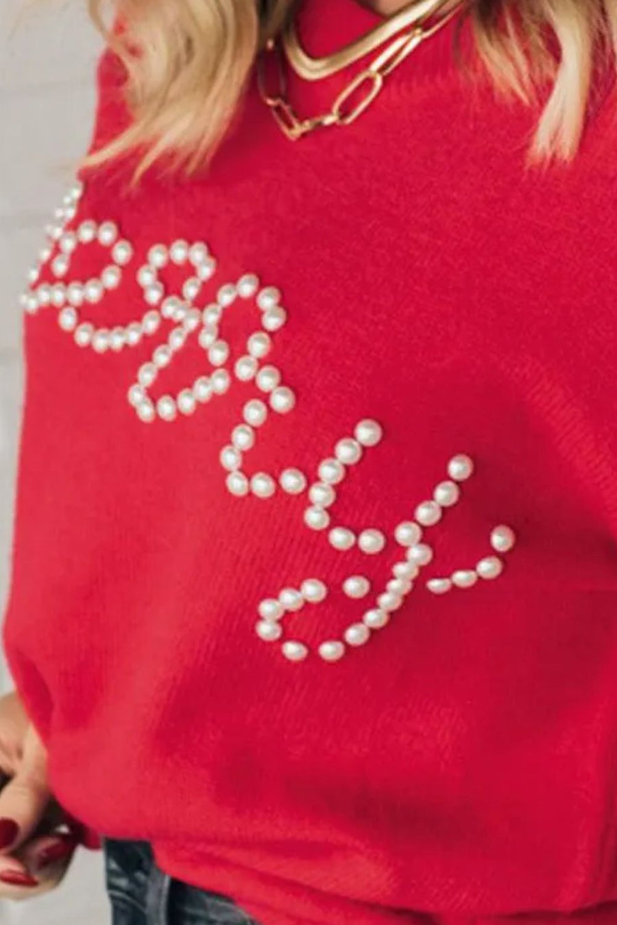 Red sweater with pearl embellished "Merry" text detail.