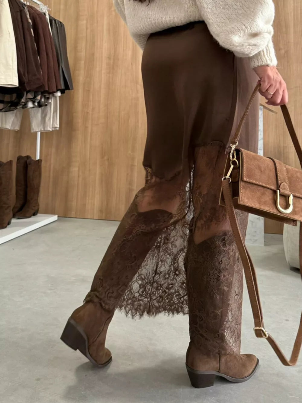 Brown midi skirt with lace trim detail, styled with boots and a handbag.