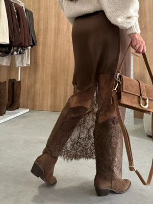 Brown midi skirt with lace trim detail, styled with boots and a handbag.