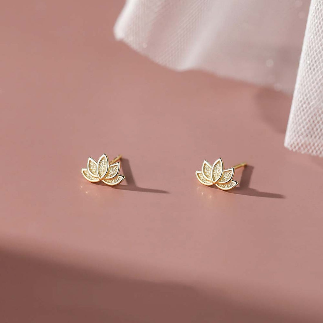 Gold lotus flower stud earrings with delicate detailing.