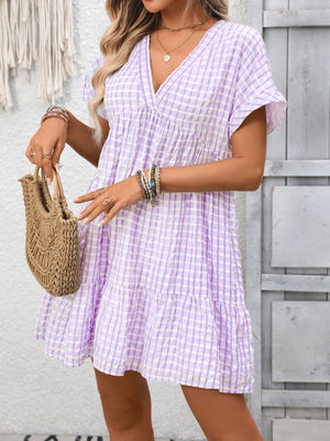 Plaid V-neck mini dress in light purple with short sleeves and tiered hem.