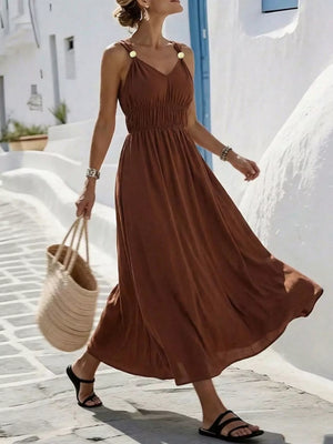 Brown sleeveless V-neck maxi dress with smocked waist and gold-button straps.