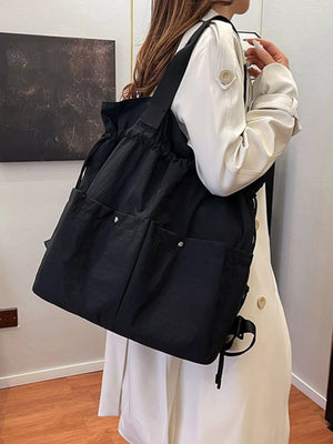 Black drawstring backpack with multiple exterior pockets and adjustable straps.