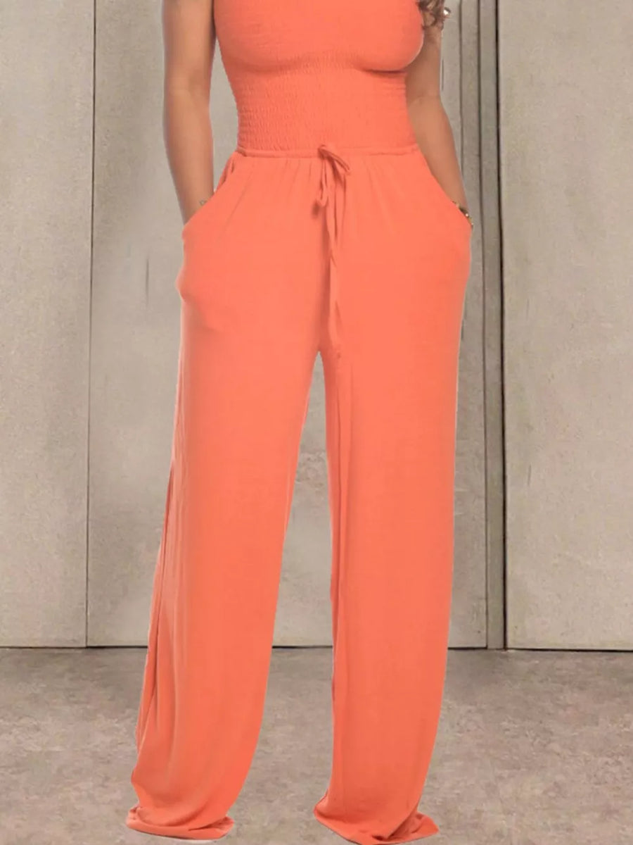 Orange smocked wide-leg jumpsuit with drawstring waist and pockets