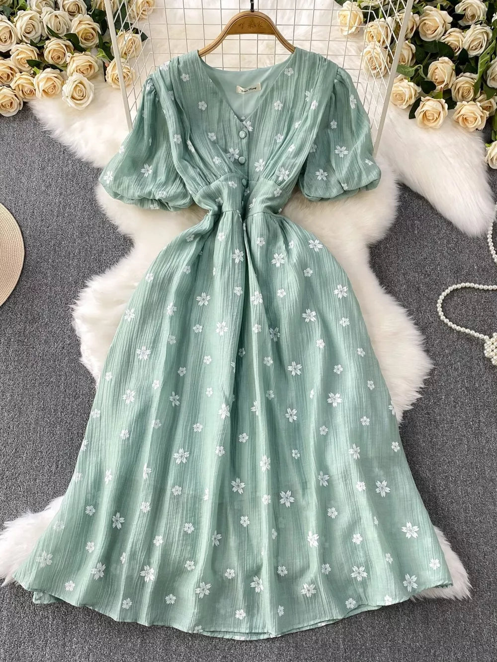 Light green embroidered puff sleeve midi dress with button detail and V-neck.