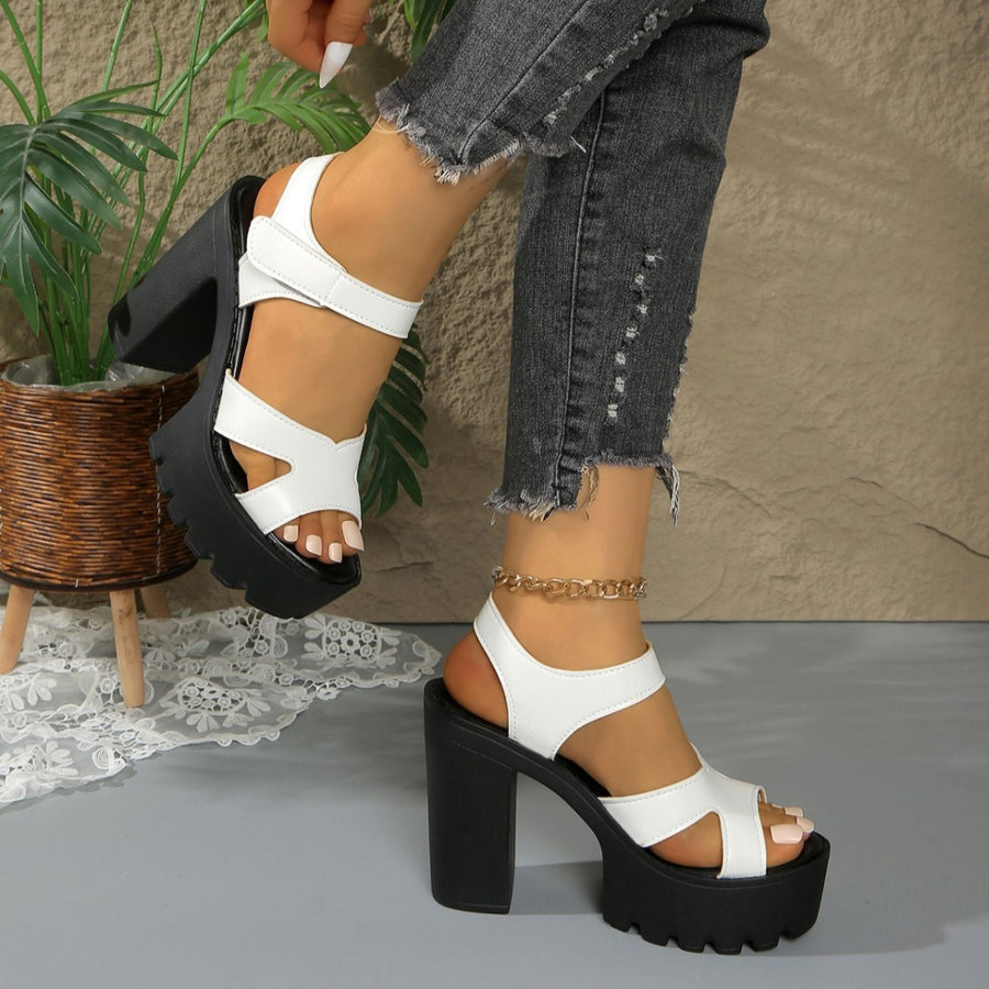 White open-toe block heel sandals with black chunky sole and platform.