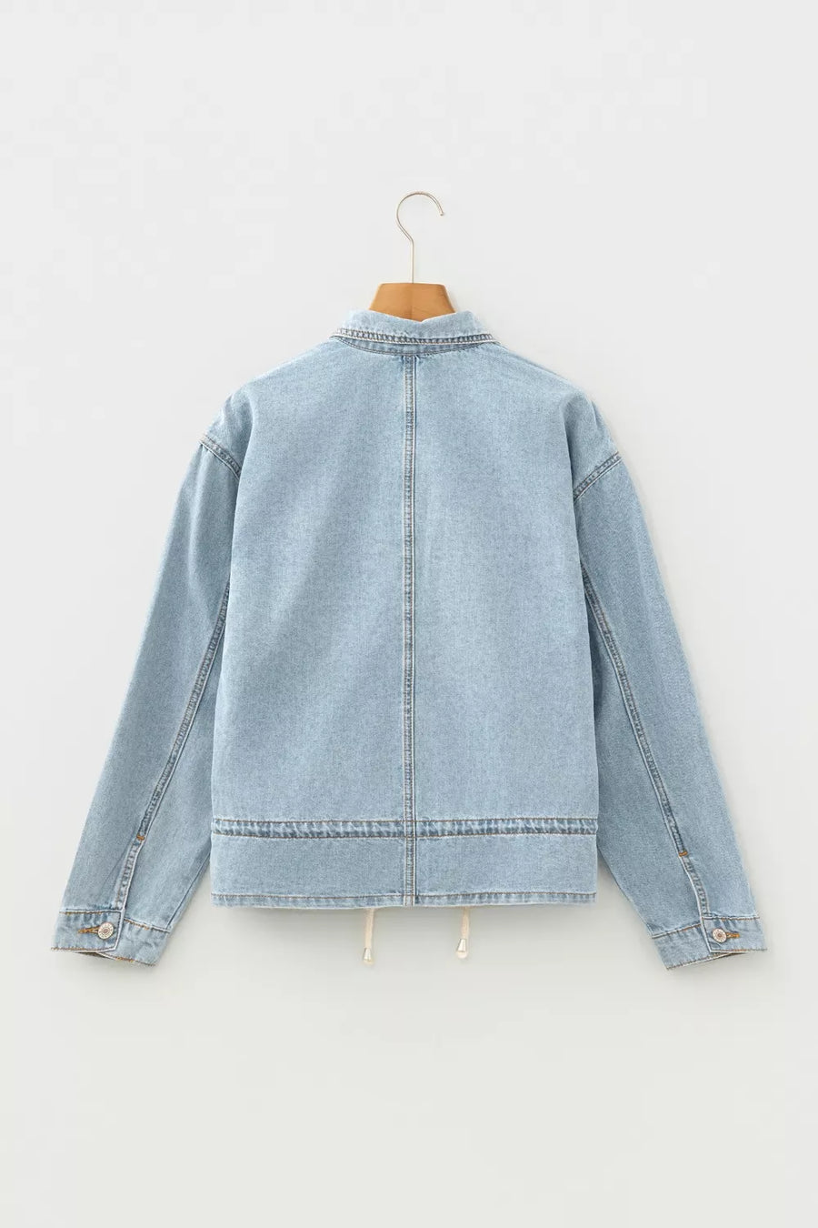 Light wash denim trucker jacket with relaxed fit and adjustable draw-cord hem.