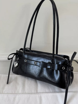 Black PU leather shoulder bag with silver heart charm and buckle details.