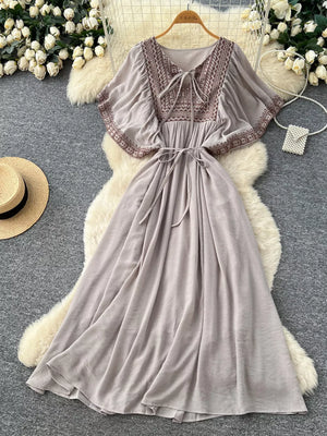 Grey embroidered V-neck bohemian maxi dress with tie detail and flutter sleeves.