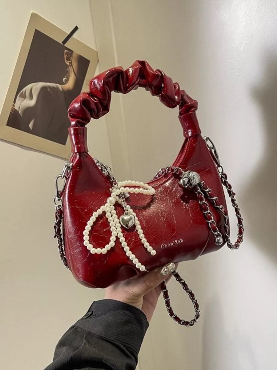 Burgundy ruched mini crossbody bag with pearl and heart pendant detail