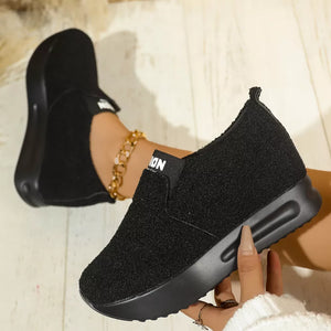 Black textured round toe platform sneakers with white "ION" detail on elastic band.