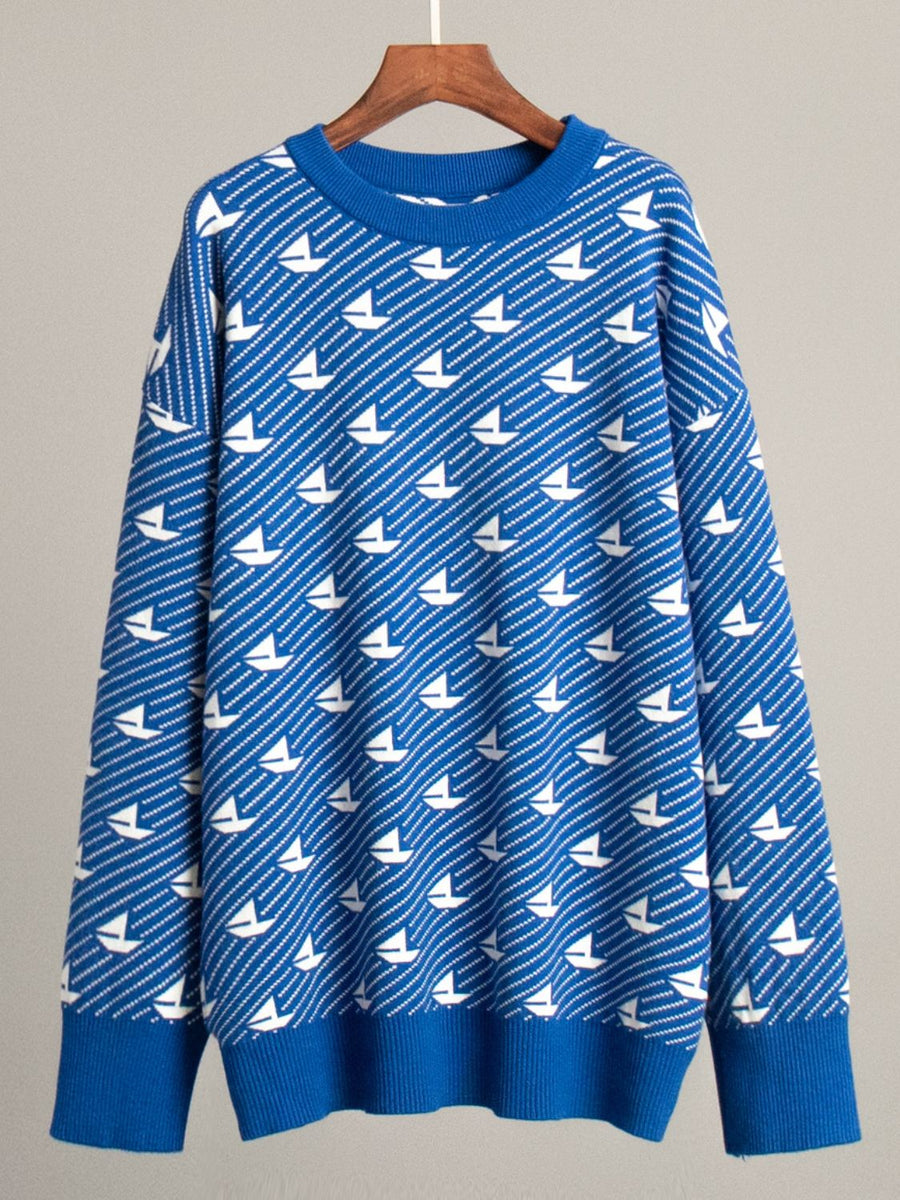 Royal blue knit sweater with white sailboat pattern, crew neck, long sleeves, ribbed cuffs and hem.