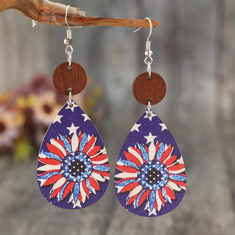 Patriotic teardrop earrings with sunflower print and stars, on alloy hooks with wood accent.