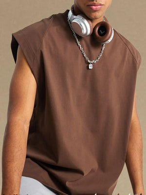 Brown raglan shoulder sleeveless top with a relaxed fit, styled with a chain necklace.